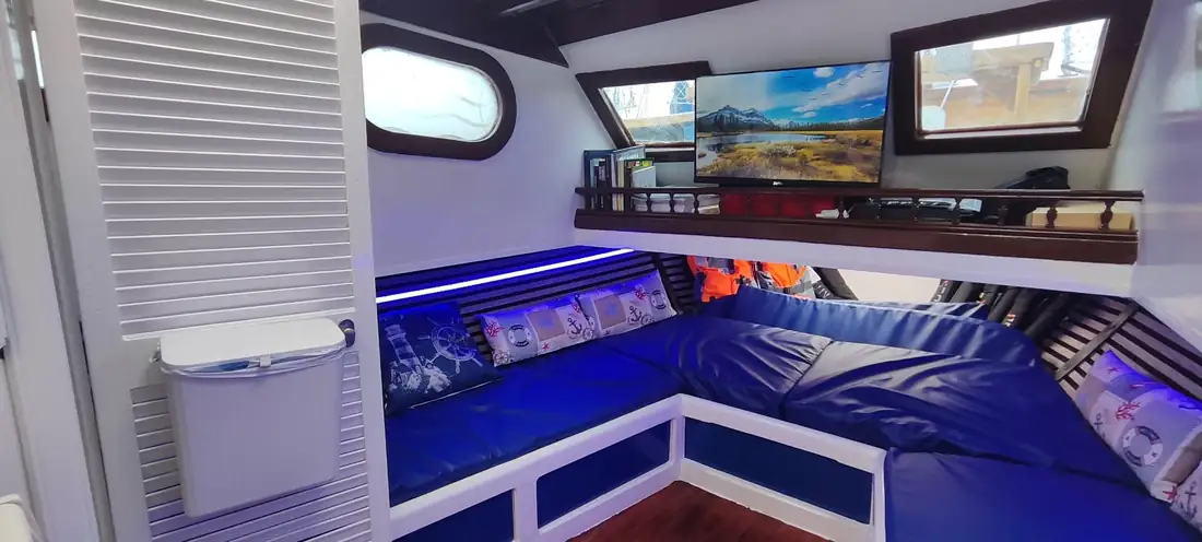 Salón interior con bancadas azules y ventanas