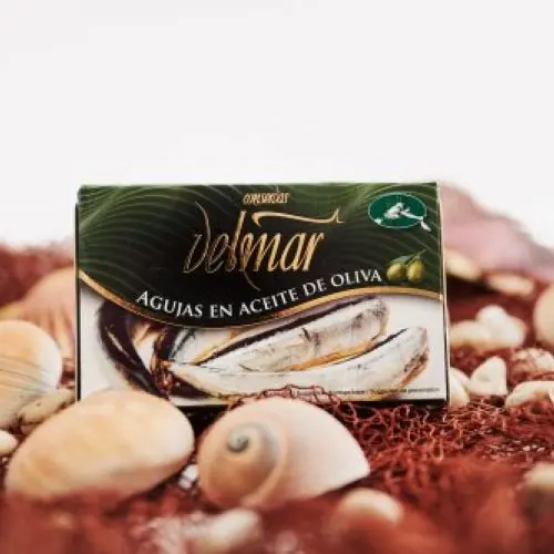 Lata de agujas en aceite de oliva sobre red de pesca y conchas
